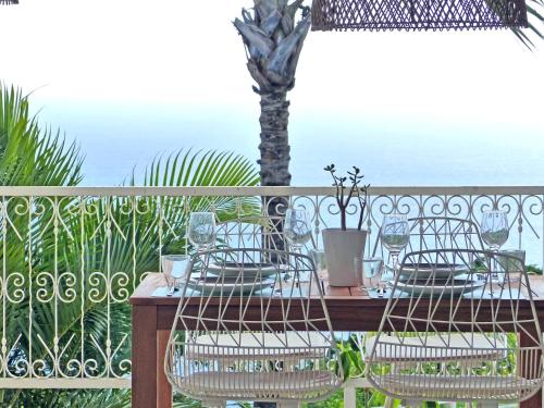 a table and chairs on a balcony with the ocean at LA BOHEME, résidence de 5 appartements avec piscine, vue océan, Petite Ile in Petite Île