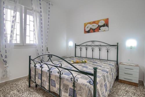 een slaapkamer met een bed met een metalen frame bij Bellevue in Marina di Pescoluse