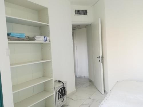 a bedroom with white shelves and a bed at Apartment By The Lake in Tiberias