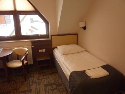 a room with two beds and a table and a window at Centrum Promocji Leśnictwa w Mucznem in Lutowiska