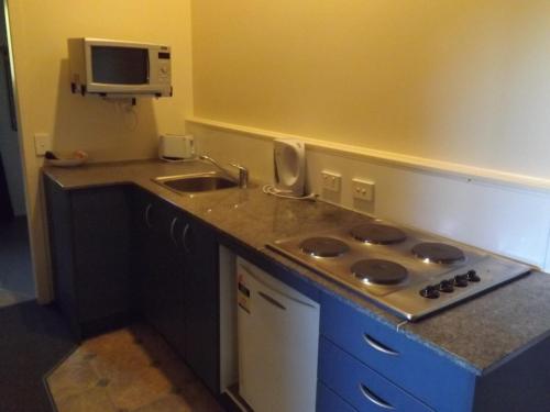 a small kitchen with a sink and a stove at Bay Road Motels in Haast