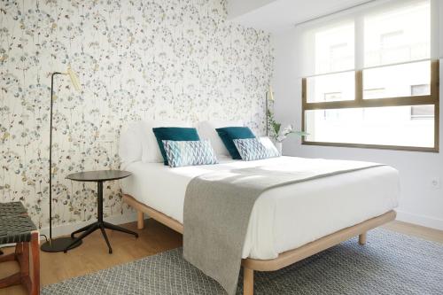 1 dormitorio con cama blanca y almohadas azules en San Francisco 2 by FeelFree Rentals, en San Sebastián