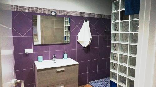 a purple bathroom with a sink and a mirror at Encinar de Aguas Blancas in Dúdar
