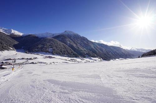 a view of a snow covered slope with mountains in the background at Unterhabererhof in Santa Maddalena in Casies