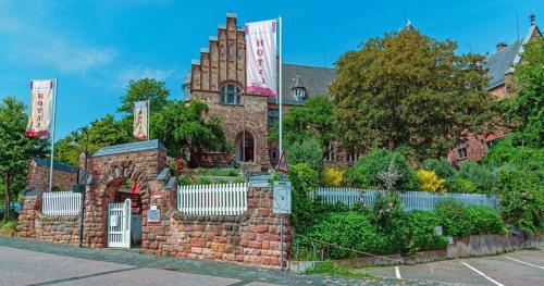 a large brick building with flags in front of it at Altes Amtsgericht Oppenheim in Oppenheim