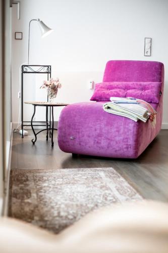 a purple couch in a living room with a table at Turm-Appartement Strandburg in Fehmarn