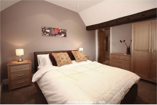 a bedroom with a large bed with white sheets and pillows at Montague House in Wokingham