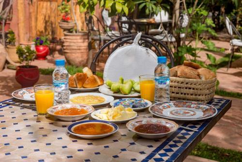 a table with plates of food and drinks on it at Hôtel Chellal ďOuzoud in Ouzoud