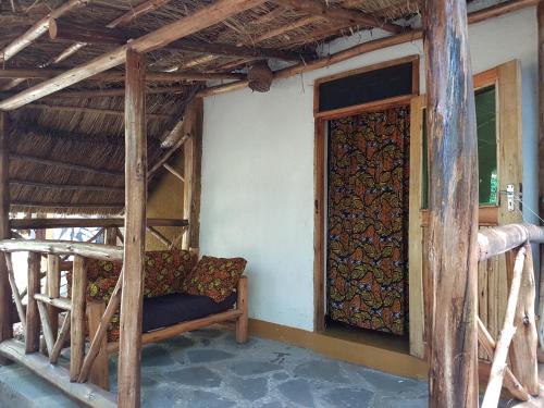 a room with a bed and a door in a house at Pumba Safari Cottages in Busonga