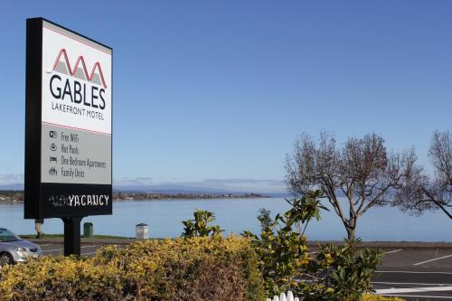 
a sign on the side of a road near a body of water at Gables Lakefront Motel in Taupo
