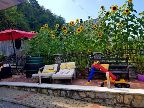a patio with sunflowers and a bench and a swing at Apartments Kamenecki in Krapina