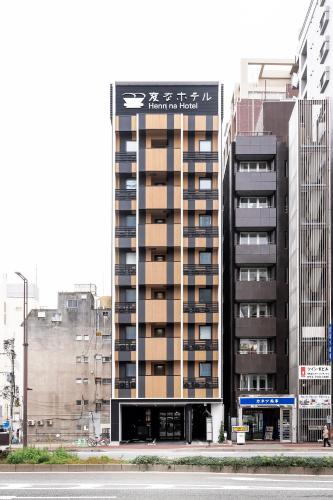 a tall building with a sign on top of it at Henn na Hotel Fukuoka Hakata in Fukuoka