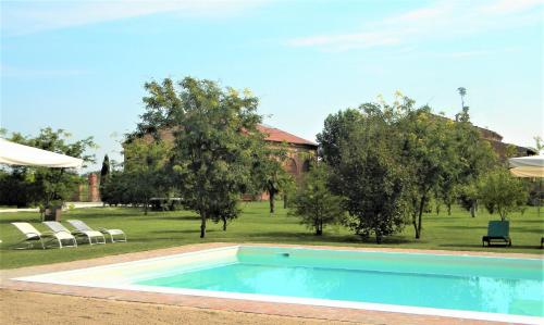una piscina en un patio con árboles en La Foresteria di Borgogelsi Apartments, en Sanguinetto