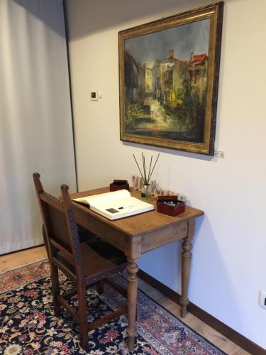 a wooden desk with a picture on the wall and a chair at Crystal Luxury House in Fiume Veneto