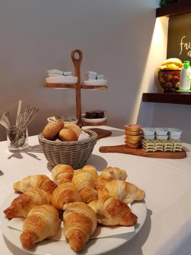 a plate of pastries on a table with a basket of bread at Hotel Stipe in Drage