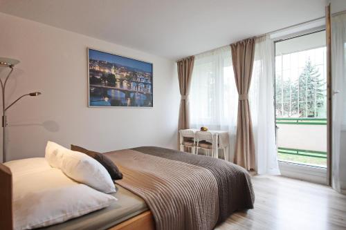 sypialnia z łóżkiem i dużym oknem w obiekcie Invalidovna Apartment w Pradze