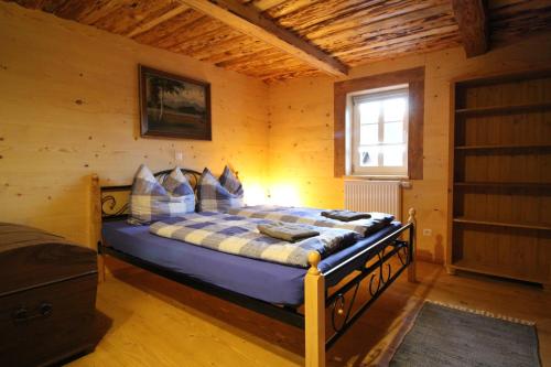 ein Schlafzimmer mit einem Bett in einem Holzzimmer in der Unterkunft Ferienhaus Anno Dazumal, wie zu Opa`s Zeiten in Klingenthal
