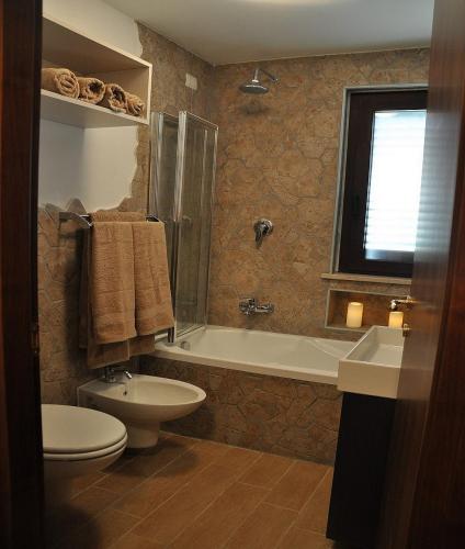 a bathroom with a toilet and a tub and a sink at Tre Laghi Countryhouse Rustic Home with pool in Citta' Sant'Angelo