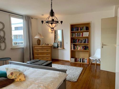 1 dormitorio con 1 cama y estantería con libros en Deluxe Business City Apartments Metzingen Villa Landenberger, en Metzingen