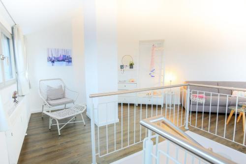 Zimmer mit einem Balkon mit einem Stuhl und einem Schreibtisch. in der Unterkunft Turm-Appartement Strandburg in Fehmarn