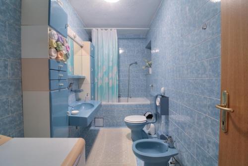 a blue bathroom with a toilet and a sink at Apartment Lea in Senj