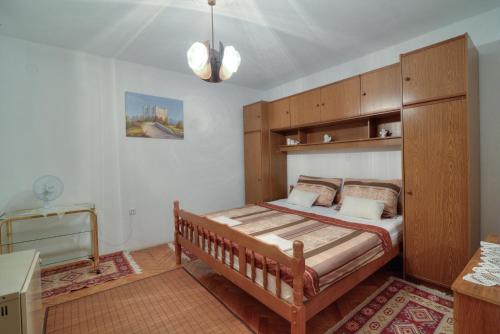 a bedroom with a bed with a wooden headboard at Apartment Lea in Senj