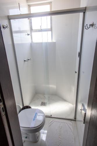 a small bathroom with a toilet and a shower at Panorama Convention Hotel in Coronel Fabriciano