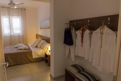 a bedroom with a bed and a closet with clothes at MareinSicilia: Appartamenti Larica in Cava D'aliga