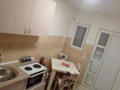 a small kitchen with a sink and a stove at Apartmani M&V in Sutomore