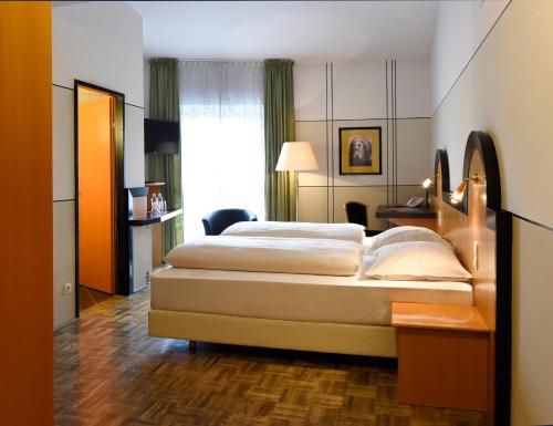 a hotel room with two beds and a window at Hotel Fuchspalast in Sankt Veit an der Glan