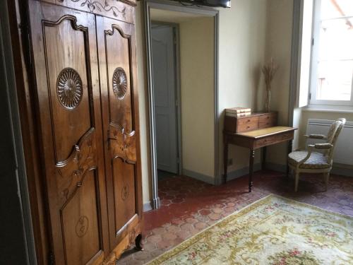a room with a large wooden door and a table at Manoir d'Aubeterre in Marsat