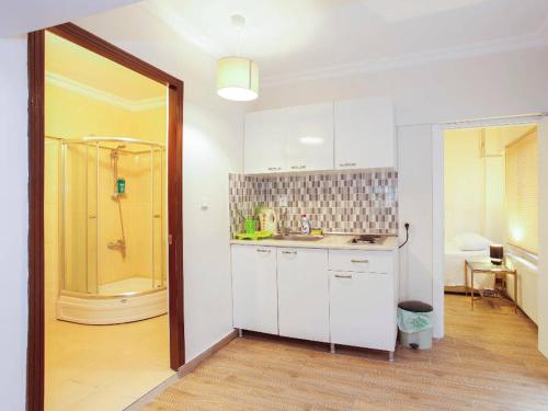 baño con ducha y cocina con armarios blancos. en Silent Corner 2, en Estambul