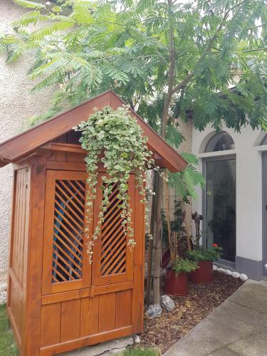 a wooden shed with a gate with flowers on it at Zur Weinlaube in Mönchhof
