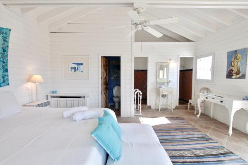 a white bedroom with a bed and a piano at El Caprichio in Gaucín