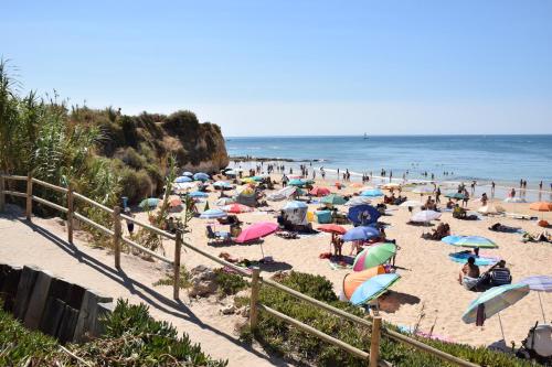 a crowd of people on a beach with umbrellas at Pé na Praia in Albufeira