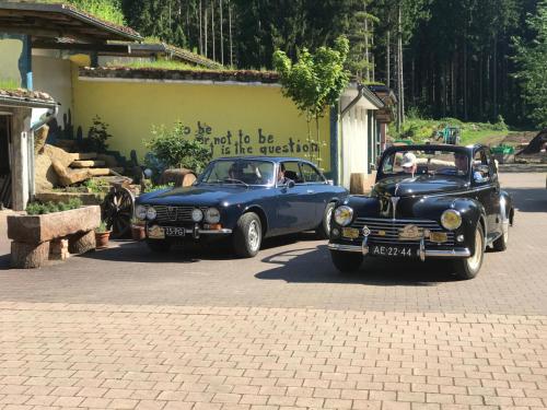 two old cars parked next to each other on a street at Hotel Hüttenmühle Hillscheid in Hillscheid