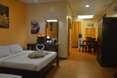 a hotel room with a bed and a dining room at Sea Garden Resort Iloilo in Iloilo City