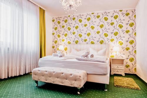 a bedroom with a white bed with a floral wallpaper at Central Hotel am Königshof in Viernheim