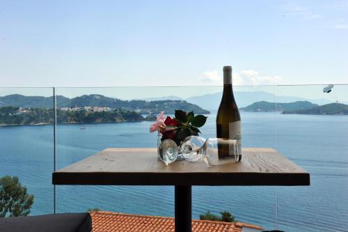 a bottle of wine and flowers on a table with a view at VILLA ALEXIS in Megali Ammos