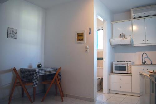 BAY VIEW STUDIO في Megas Gialos - Nites: مطبخ صغير مع طاولة وميكروويف