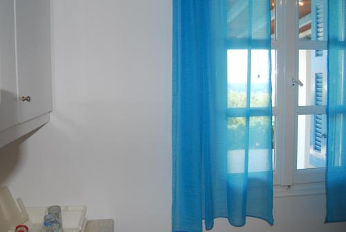 a blue curtain in front of a window at BAY VIEW STUDIO in Megas Gialos - Nites