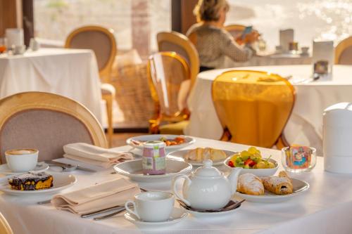 a table with plates of food and cups on it at Torre Mozza - Dimora d' Epoca in Follonica