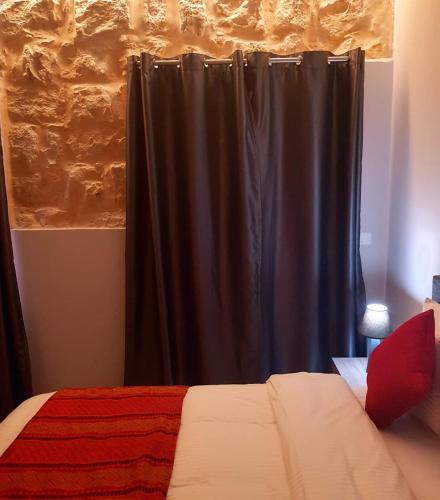 a bedroom with a bed with a black curtain at Beit Lebbos Boutique Hotel in Beït ed Dîne