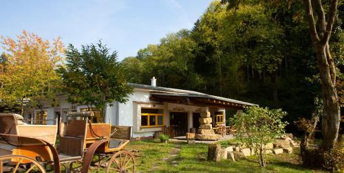 a small house with benches in front of it at Hotel Hüttenmühle Hillscheid in Hillscheid
