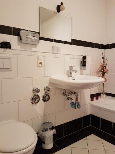 a bathroom with a white toilet and a sink at City Lodge Apartment in Leipzig