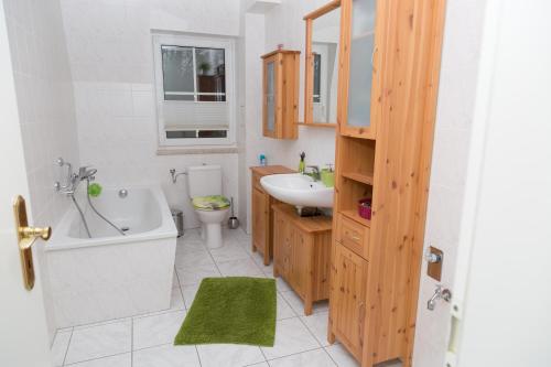 La salle de bains est pourvue d'une baignoire, d'un lavabo et de toilettes. dans l'établissement Ferienwohnung BadSaarowZentrum, à Bad Saarow