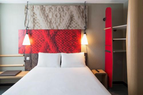 a bedroom with a bed and a red headboard at ibis Tours Nord in Tours