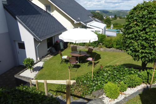 einen Garten mit einem Tisch, Stühlen und einem Sonnenschirm in der Unterkunft Ferienwohnung Bappert in Oberwesel