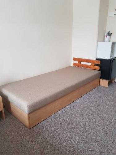 a bed with a wooden frame in a room at BLUE PENSiON in Svoboda nad Úpou