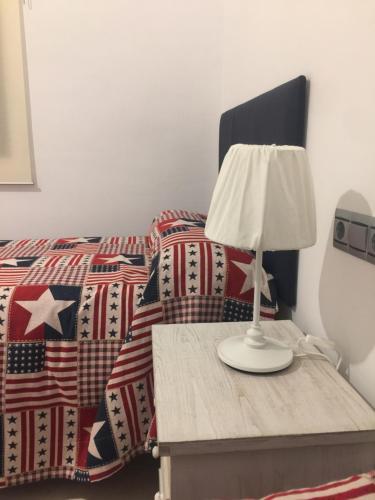 Bett mit Tisch und Lampe in der Unterkunft Ap. Palacete Marqués d la Vega in Antequera